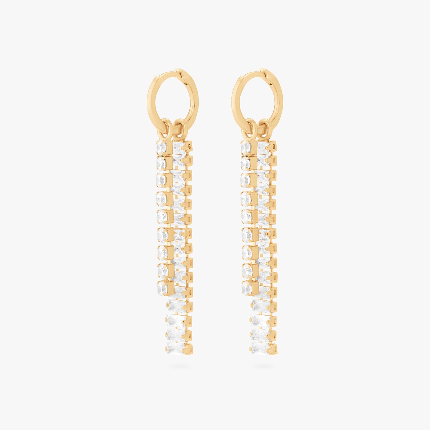 This is an image of a pair of gold small slim huggies with a charm that consists of a string of gold/clear CZs, and a charm that consists of gold/clear baguette CZs. [pair] color:null|gold/clear