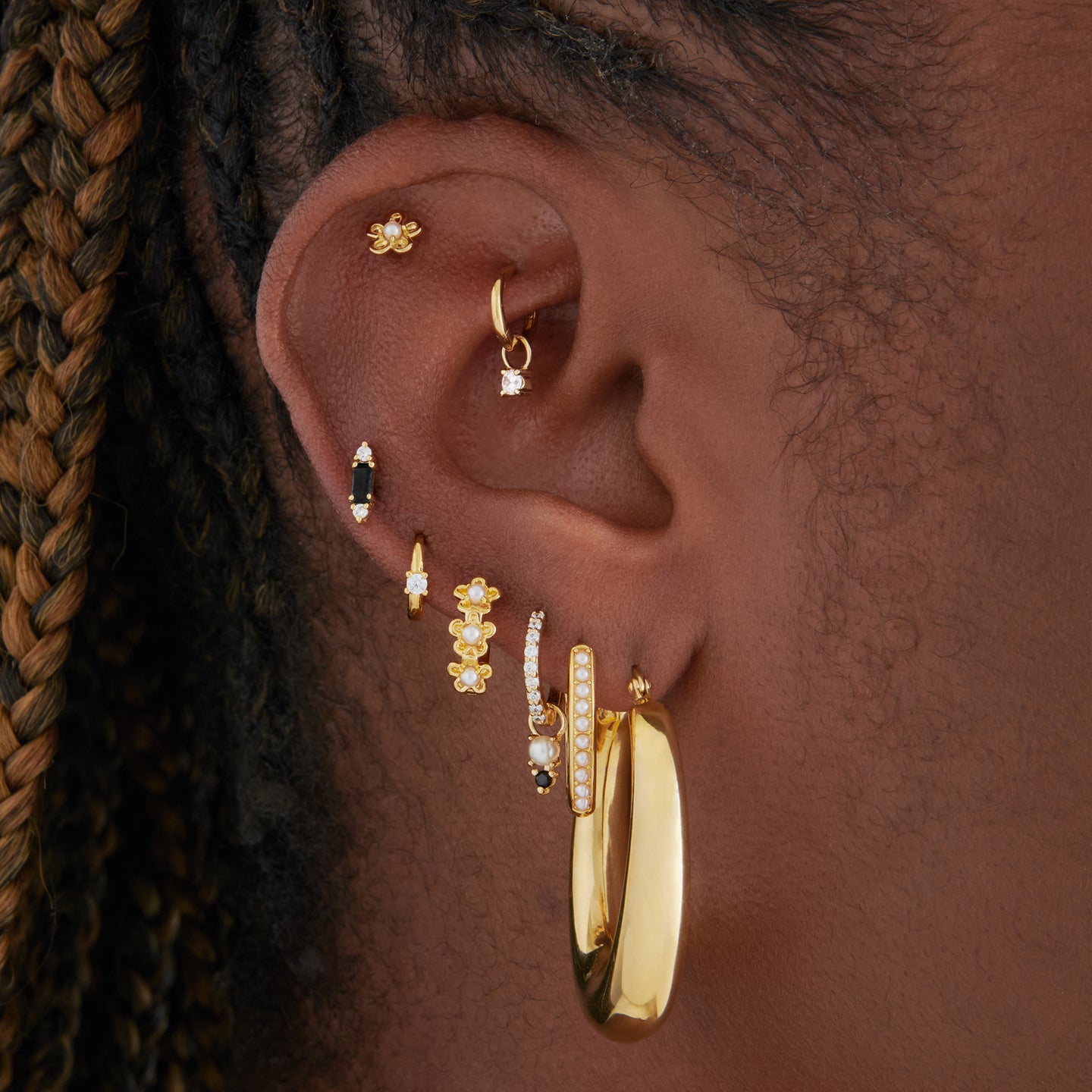 This is a gold, large, oval crescent shaped hoop on ear. [hover] color:null|gold