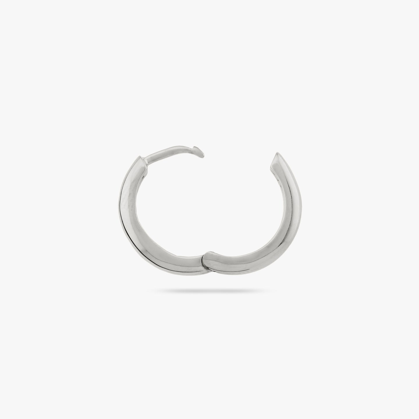 Small bulky and chunky shaped silver hoop and the clasp is undone color:null|silver