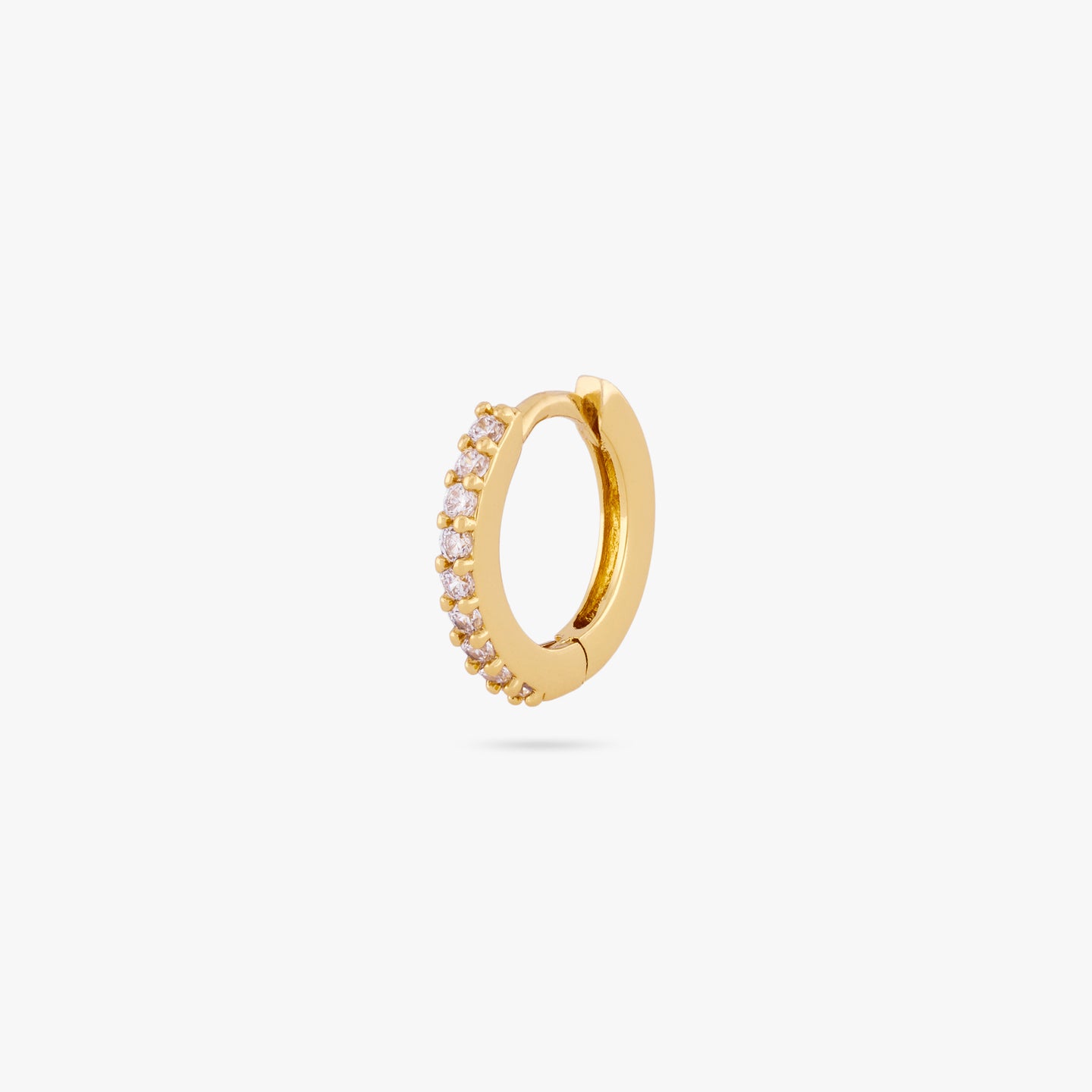 A mini gold huggie lined with clear cz gems on the front color:null|gold/clear
