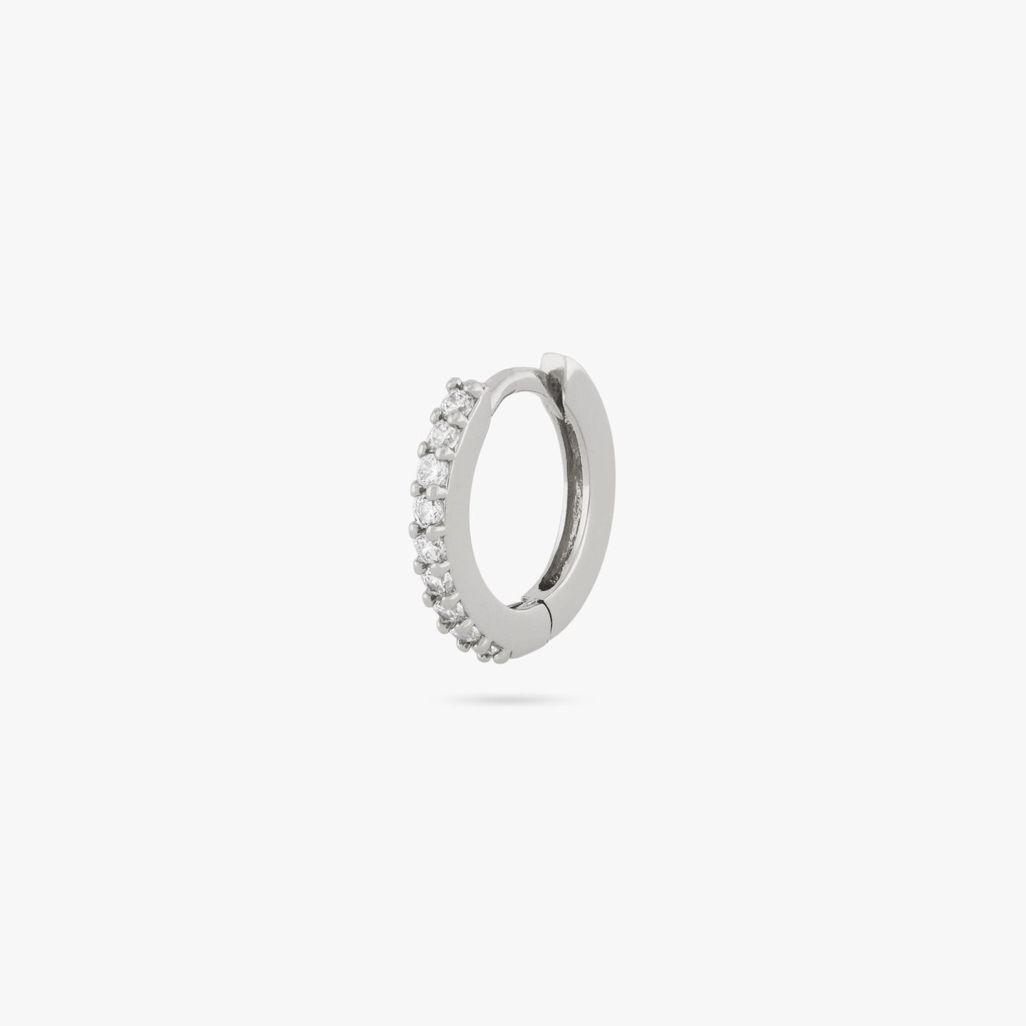 A mini silver huggie lined with clear cz gems on the front color:null|silver/clear