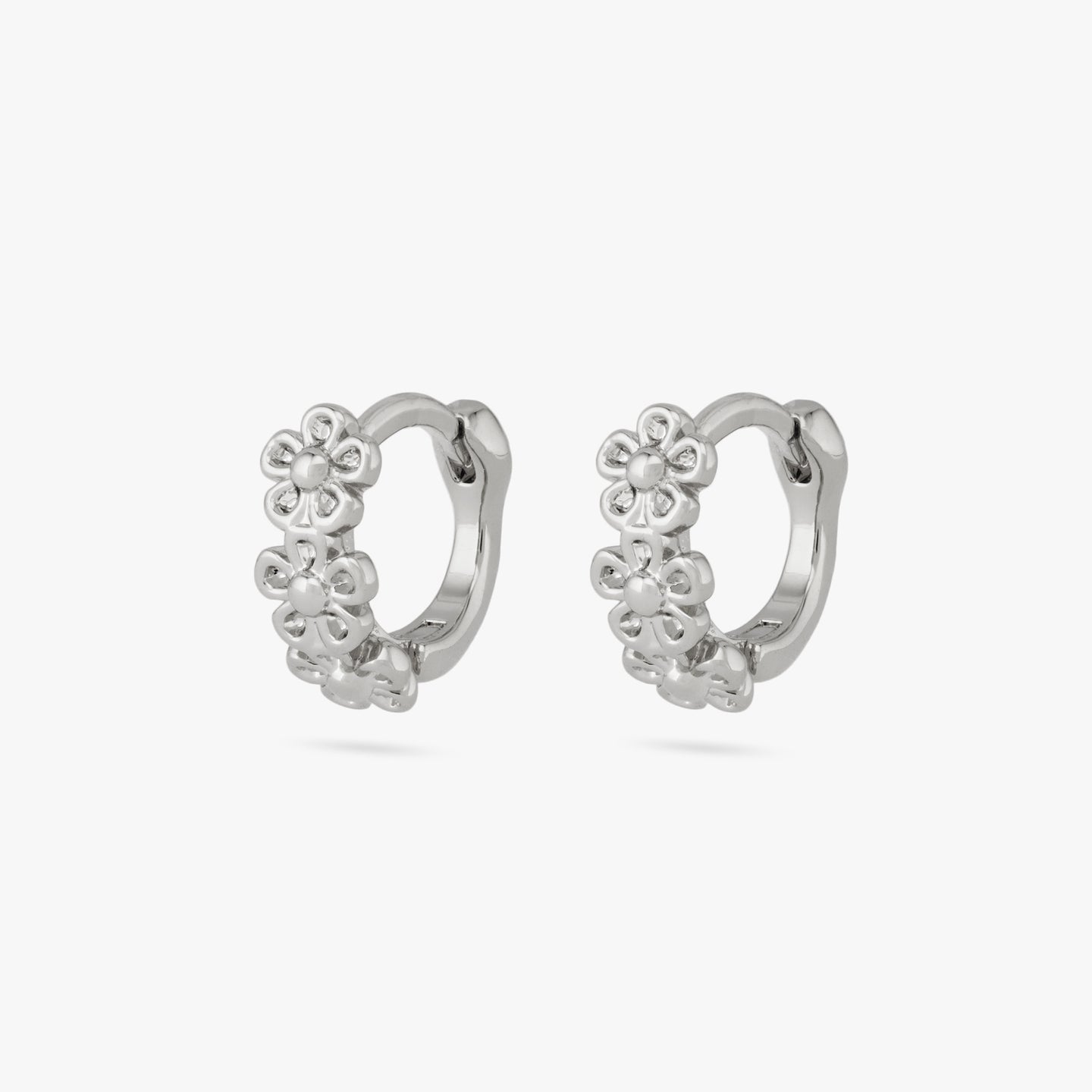 This is a pair of three small silver daisy-shaped flowers on micro huggies [pair] color:null|silver