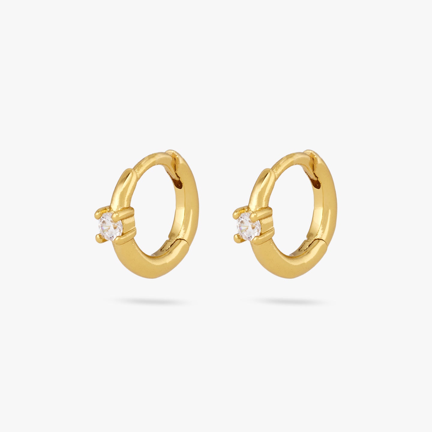 This is a pair of small gold huggies with a clear cz detail in the center of the front [pair] color:null|gold/clear