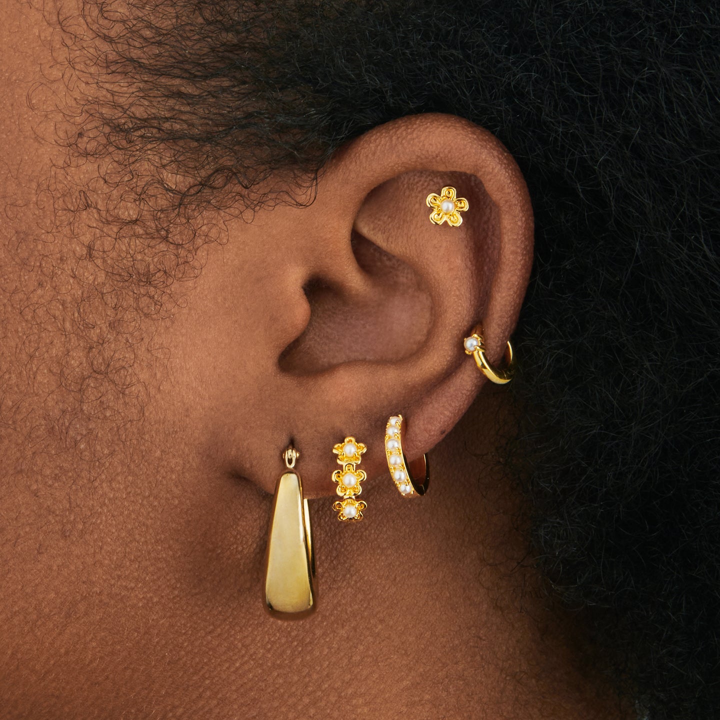 a gold small huggie with a pearl accent stone on ear [hover] color:null|gold