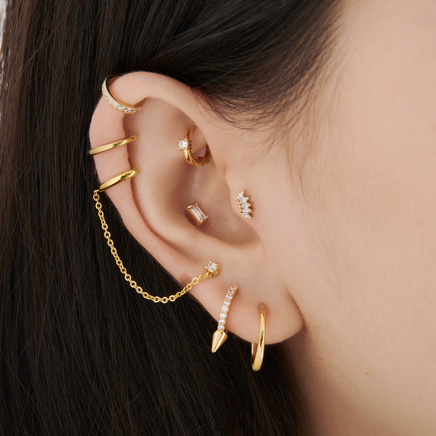 This is a small gold huggie with a clear cz detail in the center of the front on ear [hover] color:null|gold/clear