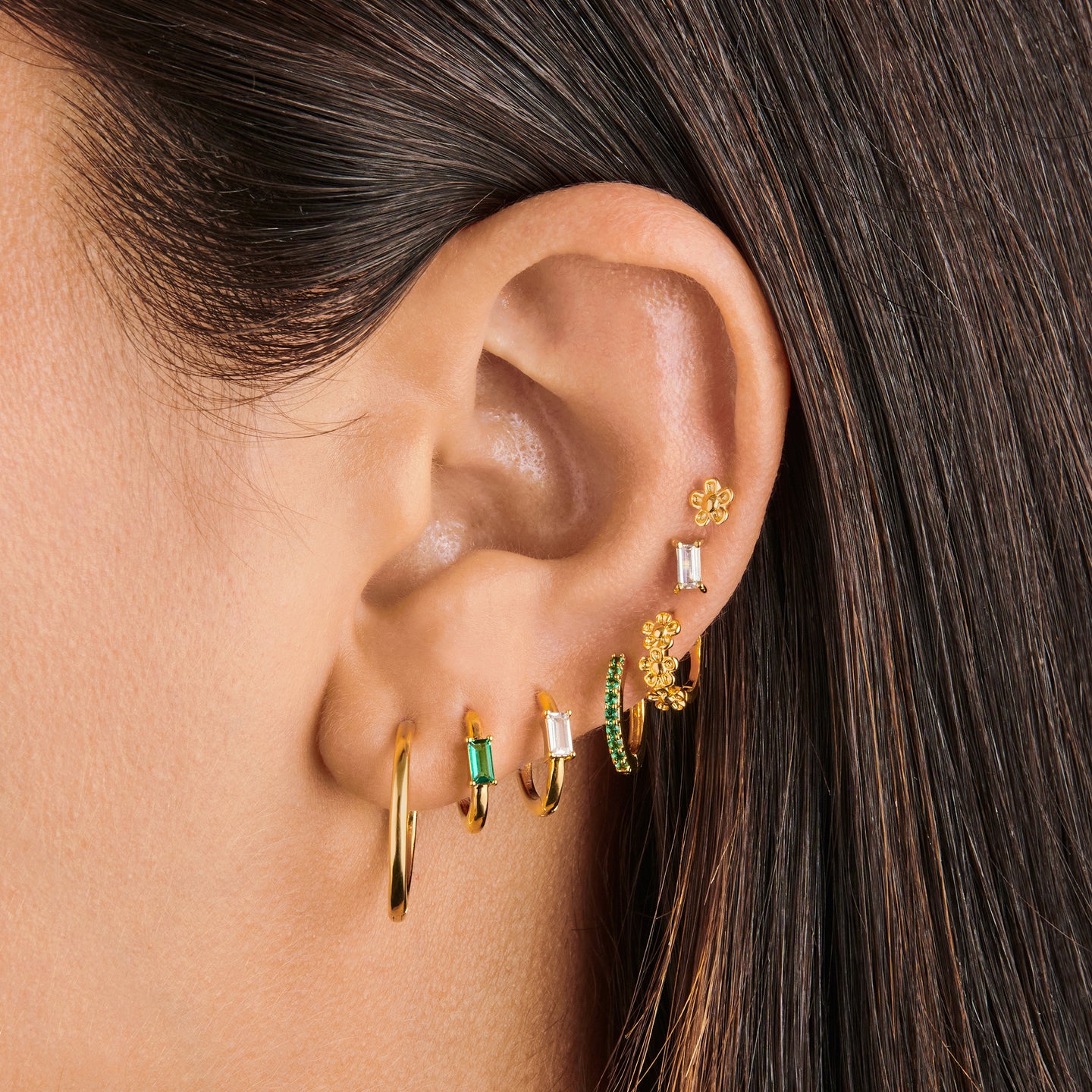 a gold small slim huggie with a green baguette cz on ear [hover] color:null|gold/green