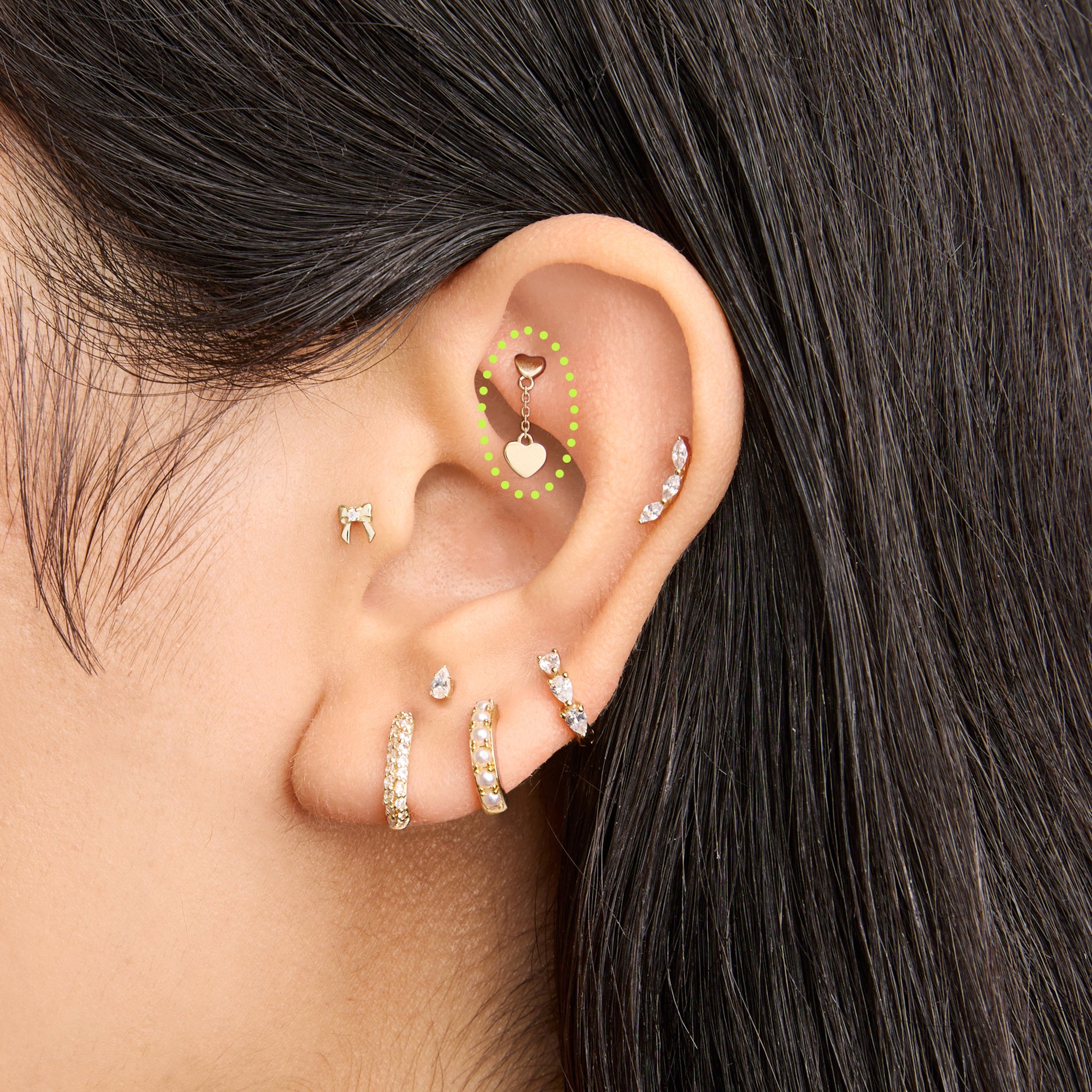 This is an image of a 14k gold flatback that is heart shaped with a gold shaped heart dangling from it on ear. [hover] color:null|14k gold/clear