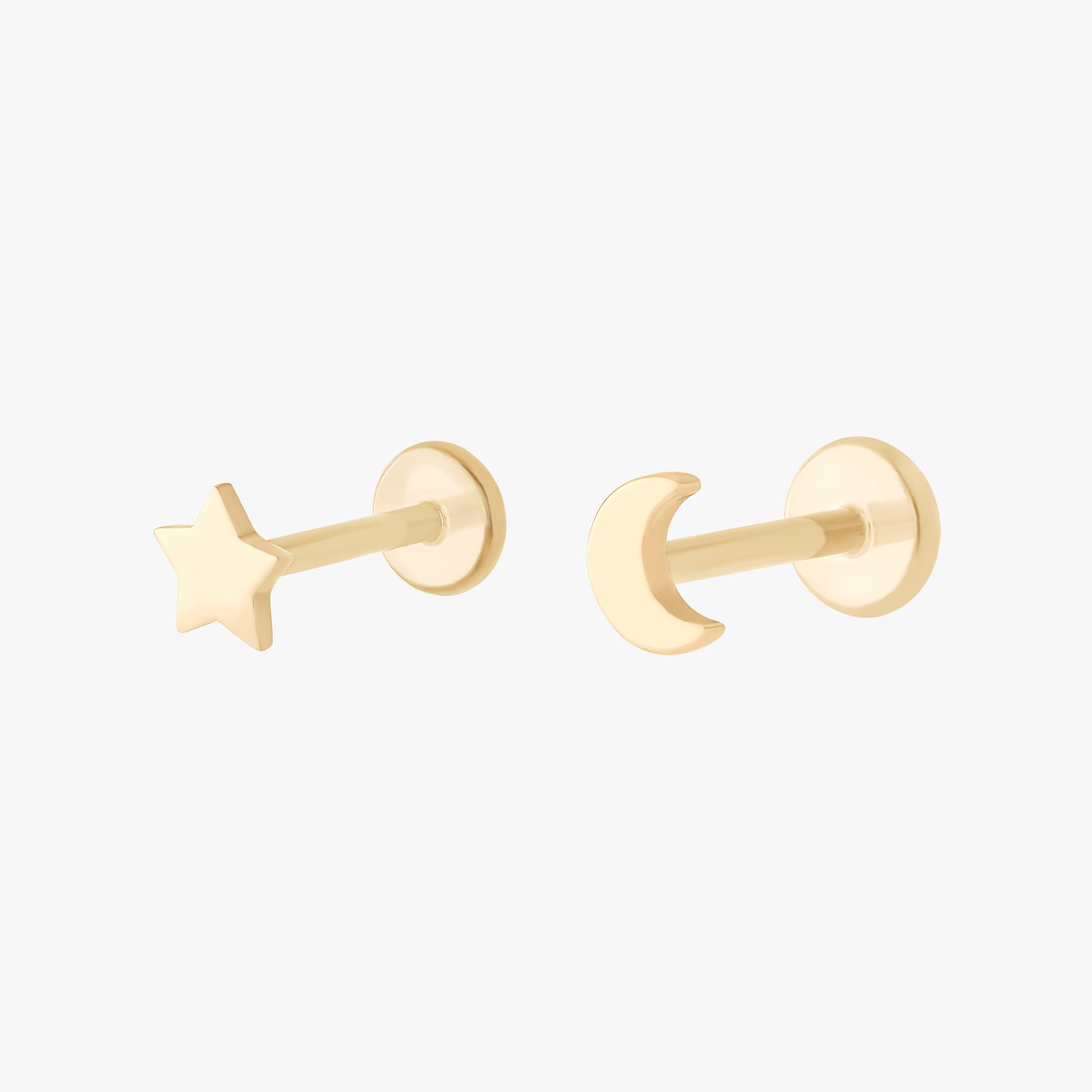 This image shows a set of 14k yellow Gold earrings. The set includes a Gold star flatback stud and a Gold moon flatback stud