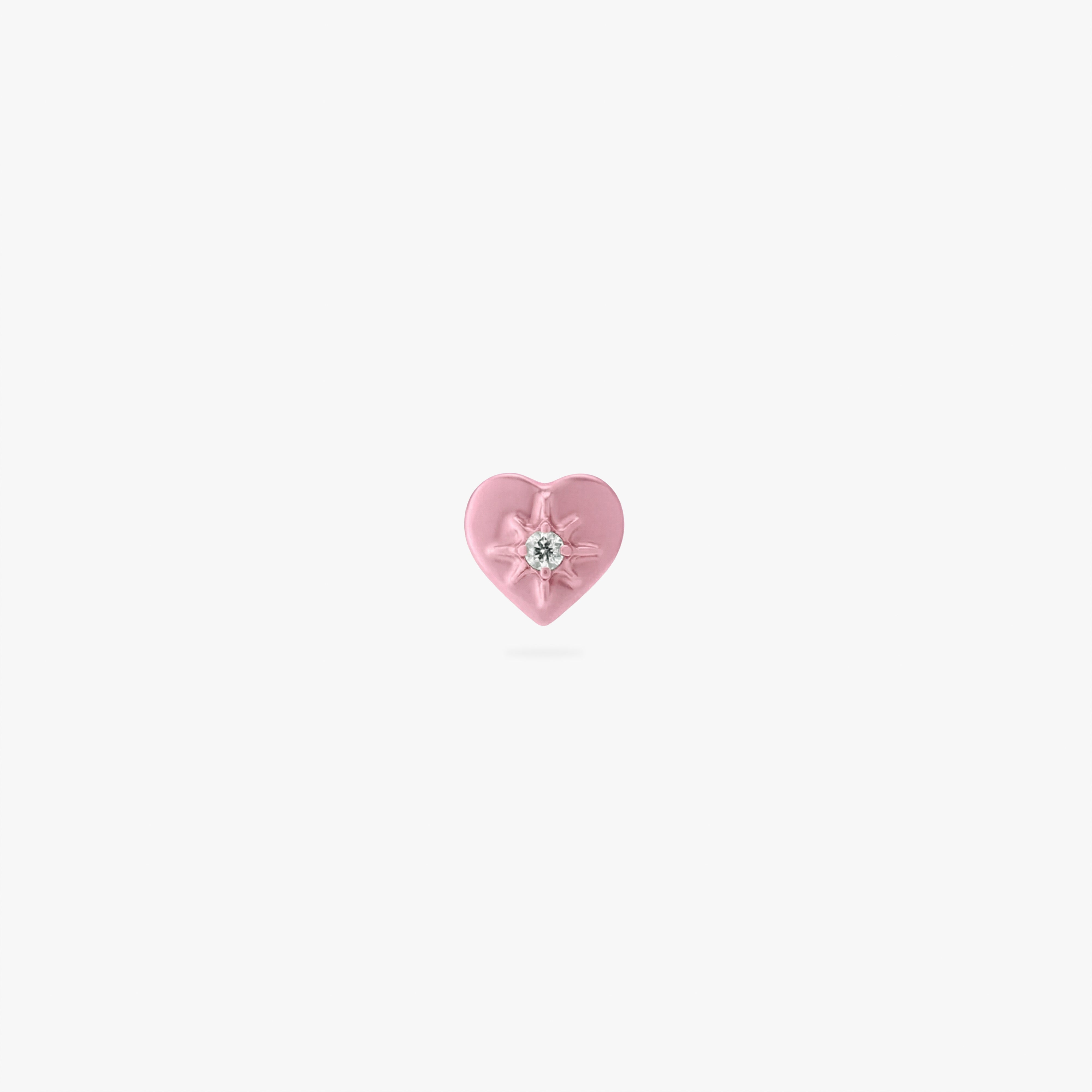 Pink heart-shaped earring with a central twinkle star with a clear gemstone on a white background