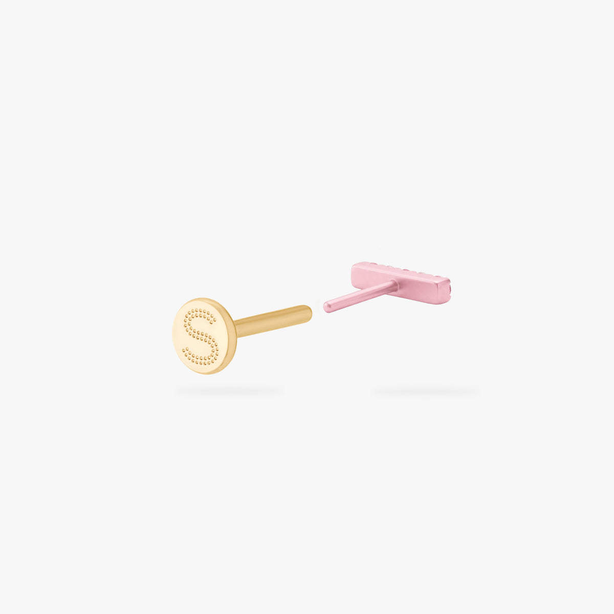 Back angle of a pink flatback stud open with a gold backing with an engraved 'S'