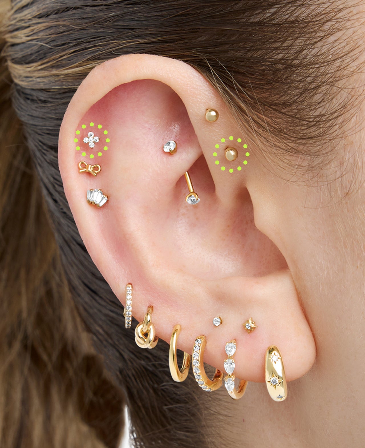on ear featuring helix and forward helix placements with a range of gold and sparkly earrings