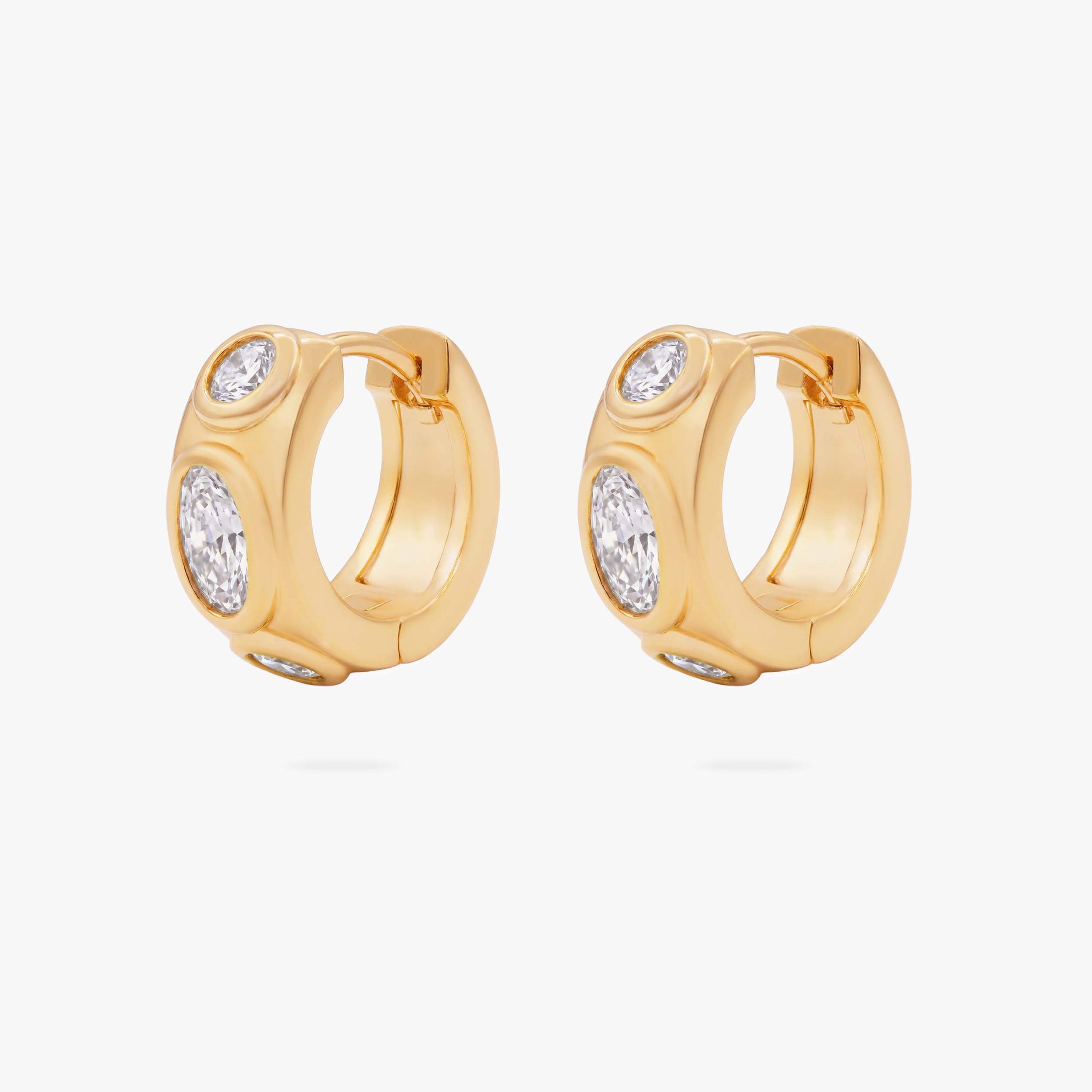 this image shows the front of a pair of 14k gold plated huggies with three clear circular cz stones - Pair view
