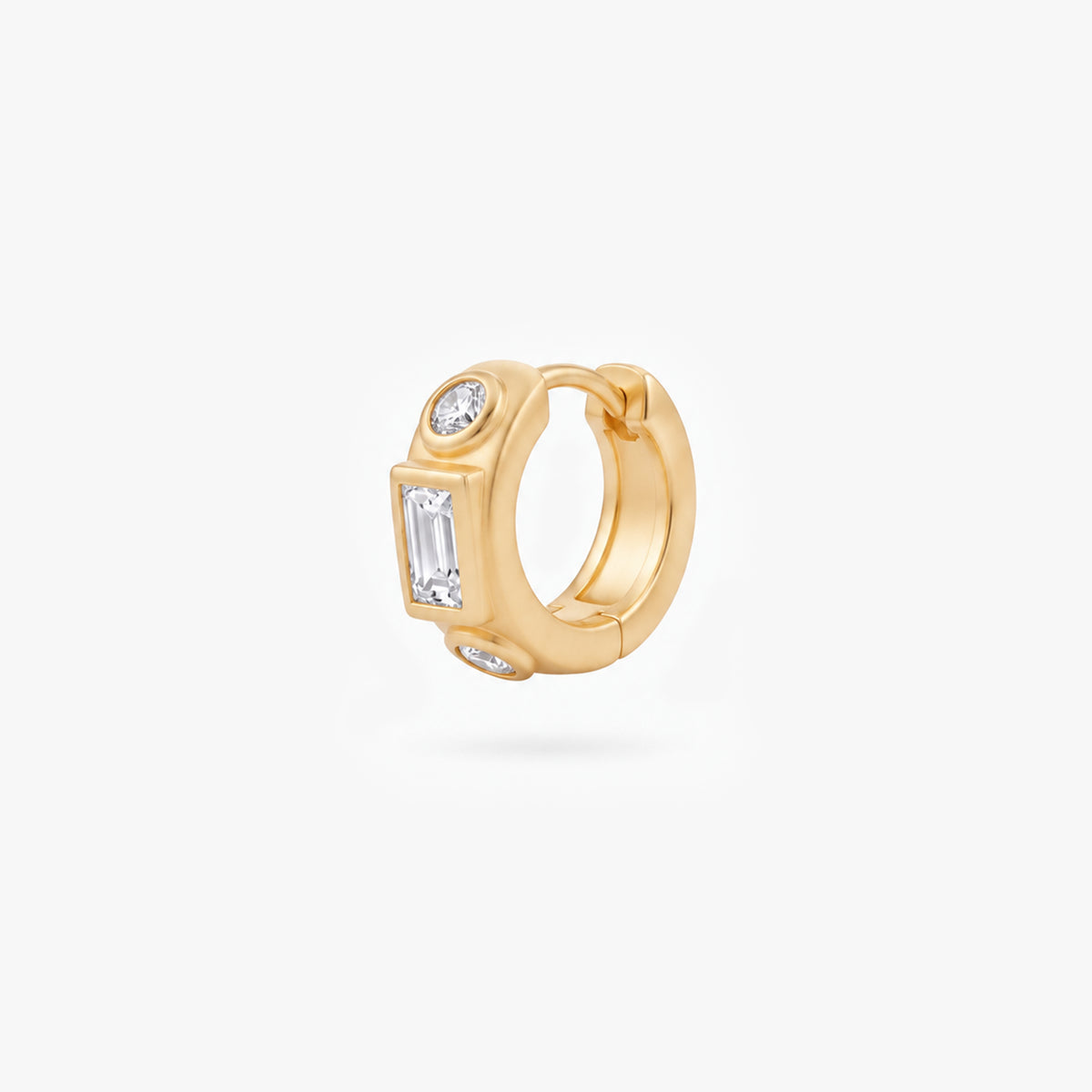 This image shows the front view of a 14k gold plated huggie with three clear cz stones. One square in the middle and two circular stones on the outside. - Main view