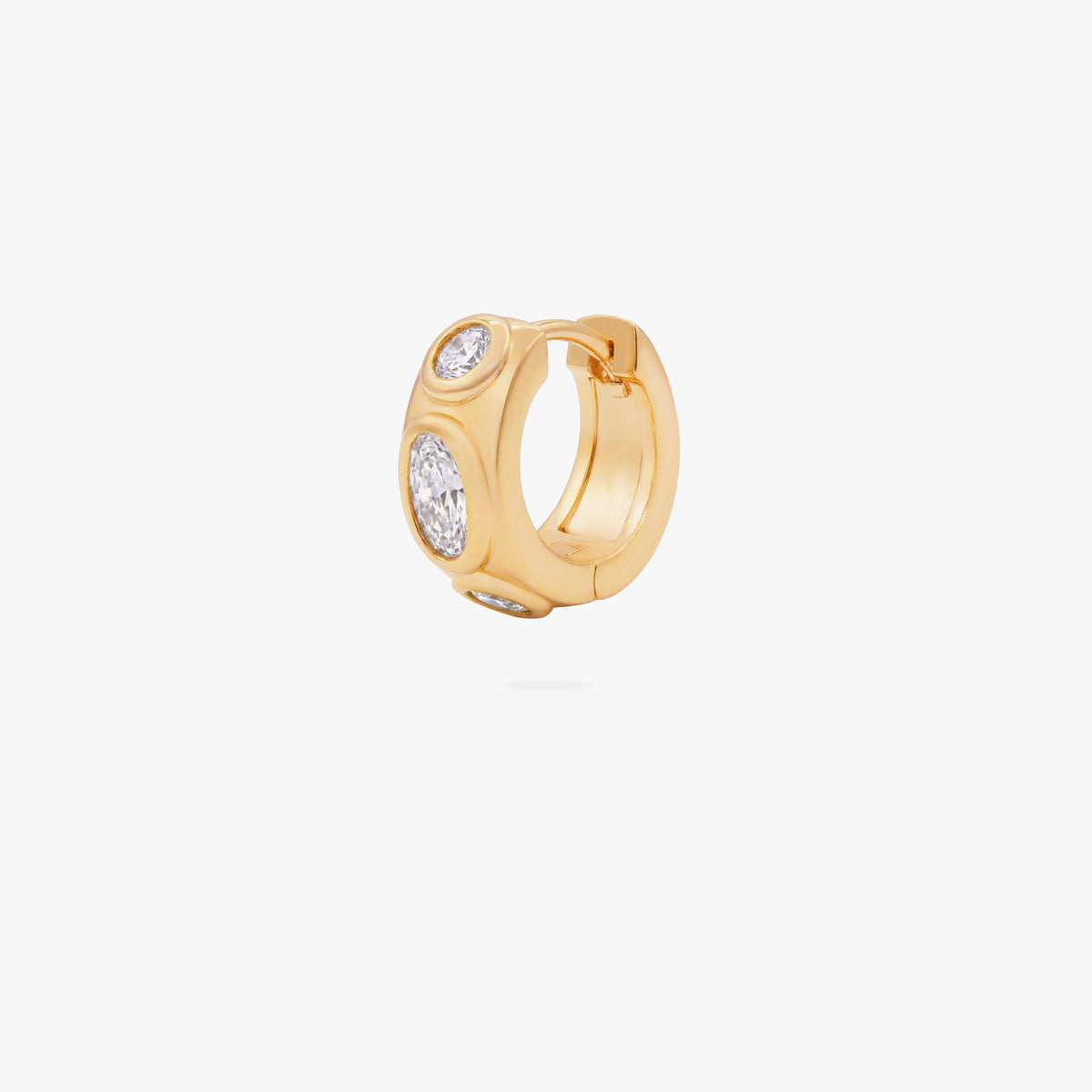 this image shows the front of a 14k gold plated huggie with three clear circular cz stones