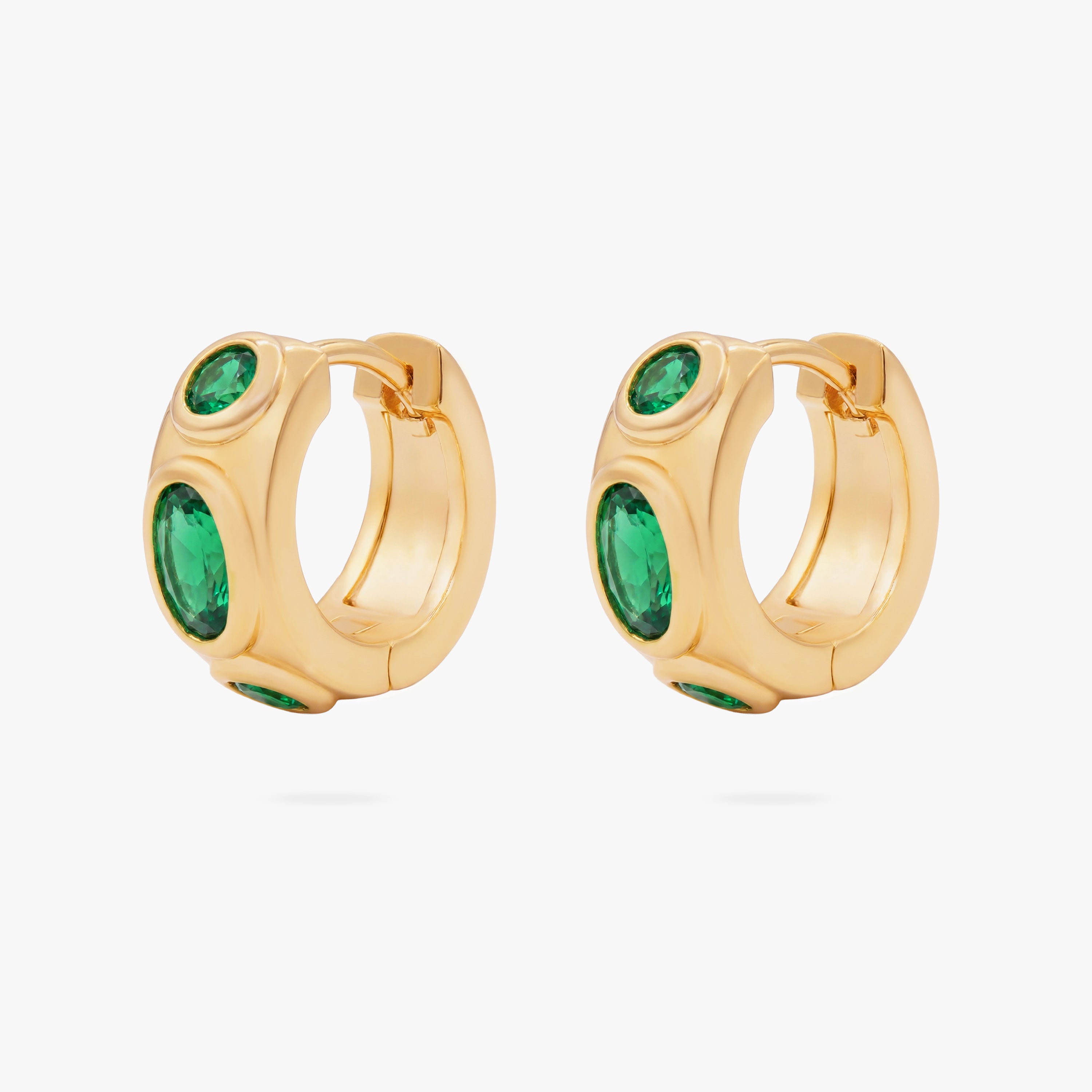 this image shows the front of a pair of 14k gold plated huggie with three green circular cz stones - Pair view