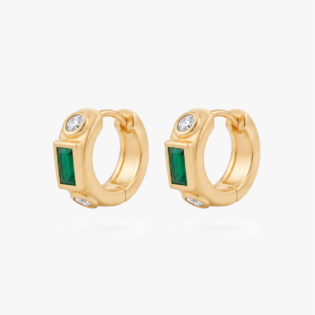 This image shows the front view of a  pair of 14k gold plated huggies with three cz stones. One green square in the middle and two clear circular stones on the outside.