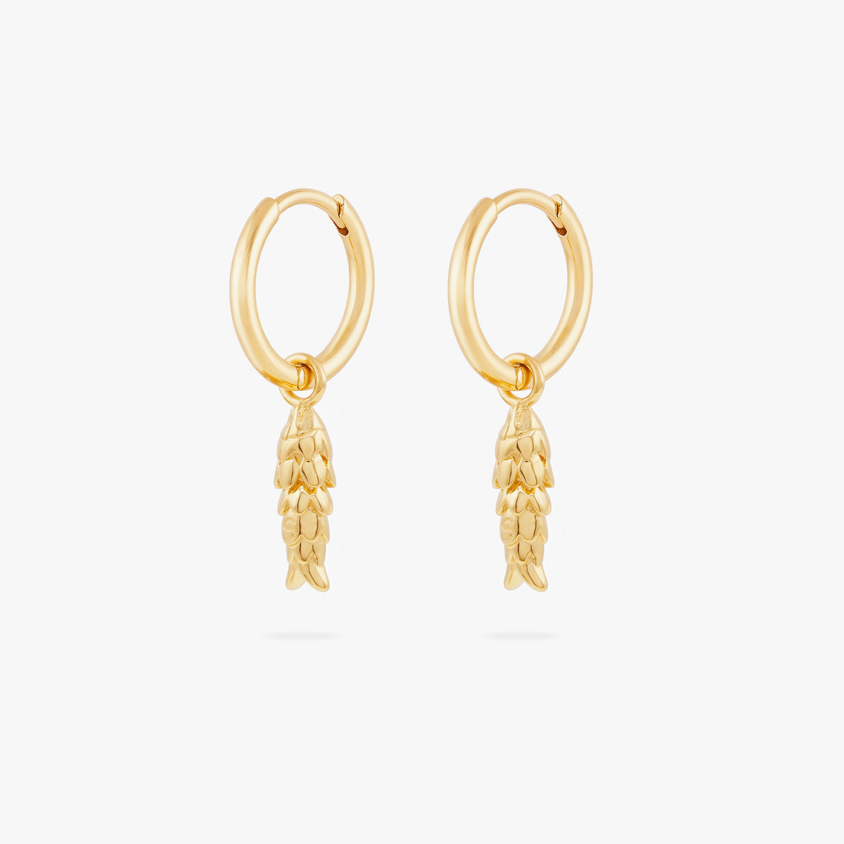 This image shows a pair of  14k gold plated huggies with dangling fish charms