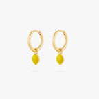 This image shows a  pair of 14k gold plated huggies with yellow lemon charms. 