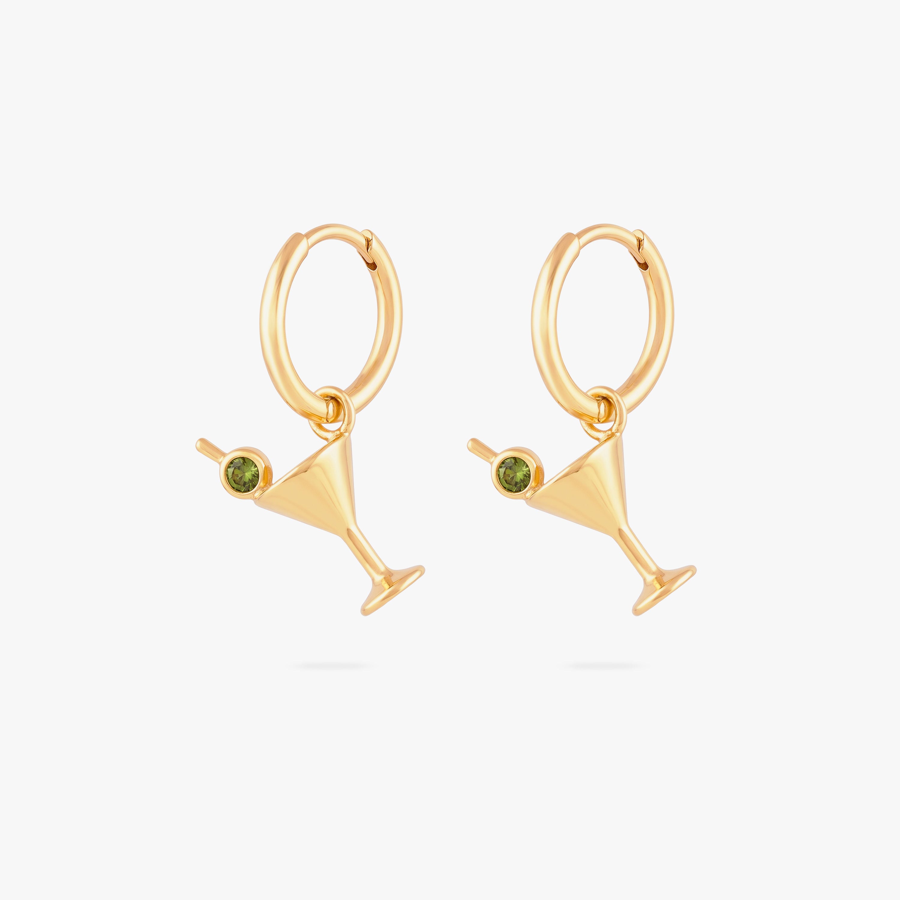 this image shows a pair of 14k gold plated huggies with  martini glass charms with a green gemstones.