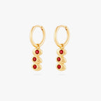 this image shows a pair of 14k gold plated huggies with three olives with a red stone in the middle of each olive. 