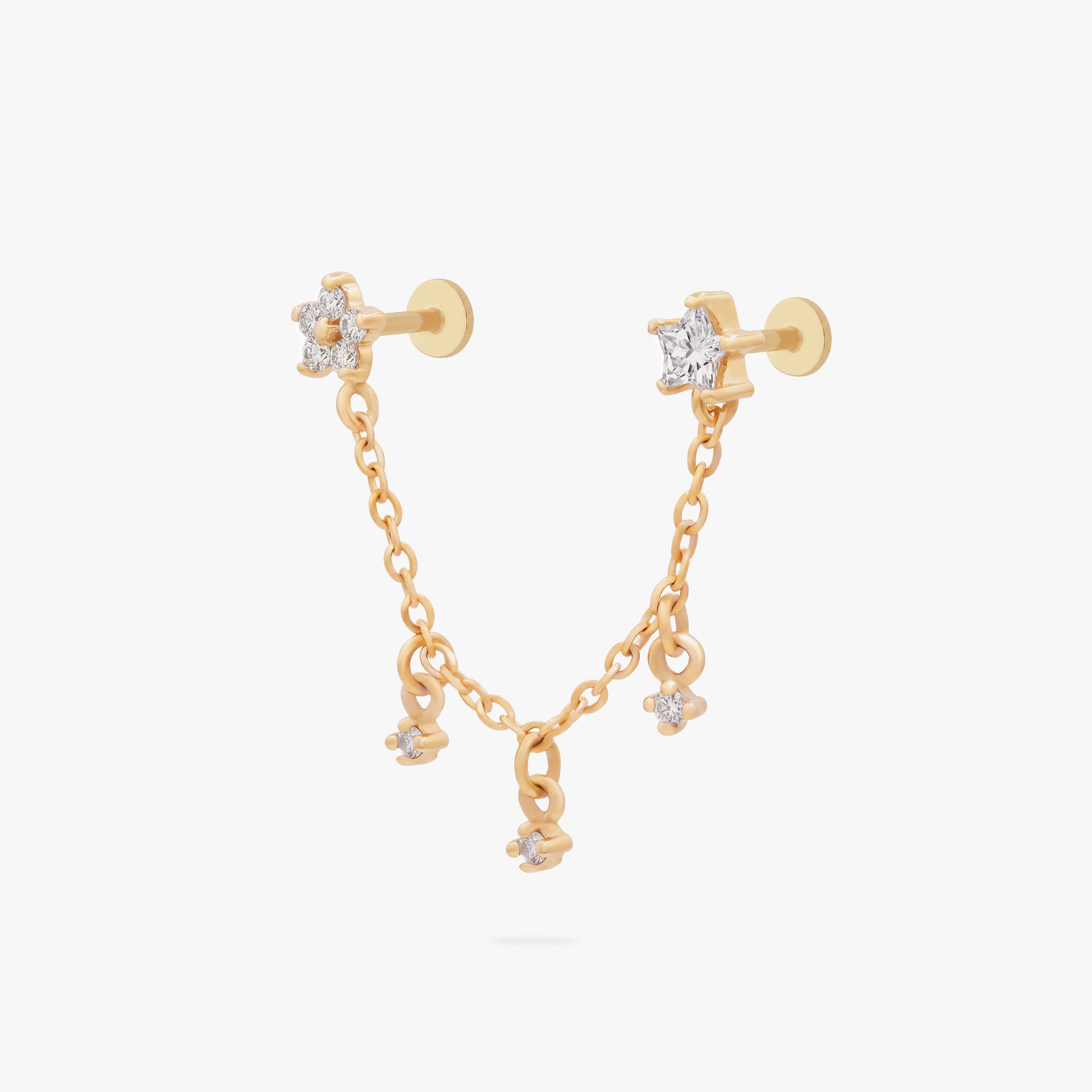 This is an anodized gold titanium chained flatback stud with two flatback posts. Each flatback stud is a clear star CZ, and there is a chain with three clear CZ stones that connect the two earrings. - Main view