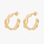 This image shows the front view of a pair of 14k gold plated hoops with an organic shapes around the hoop 