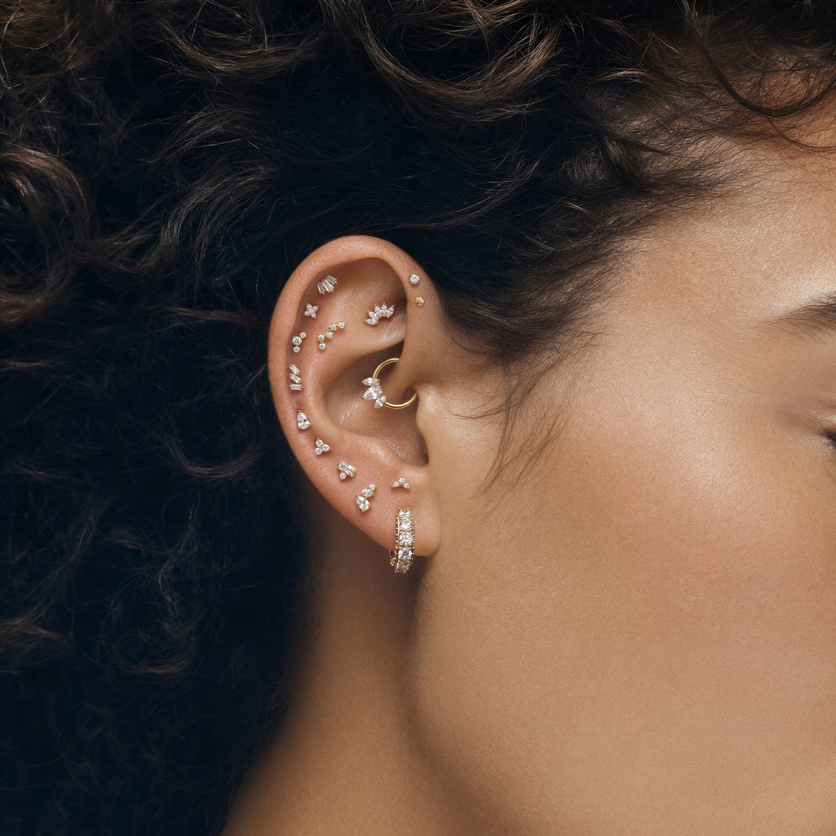 This image shows an earscape featuring the 14k pear cluster flatback with three clear cz stones