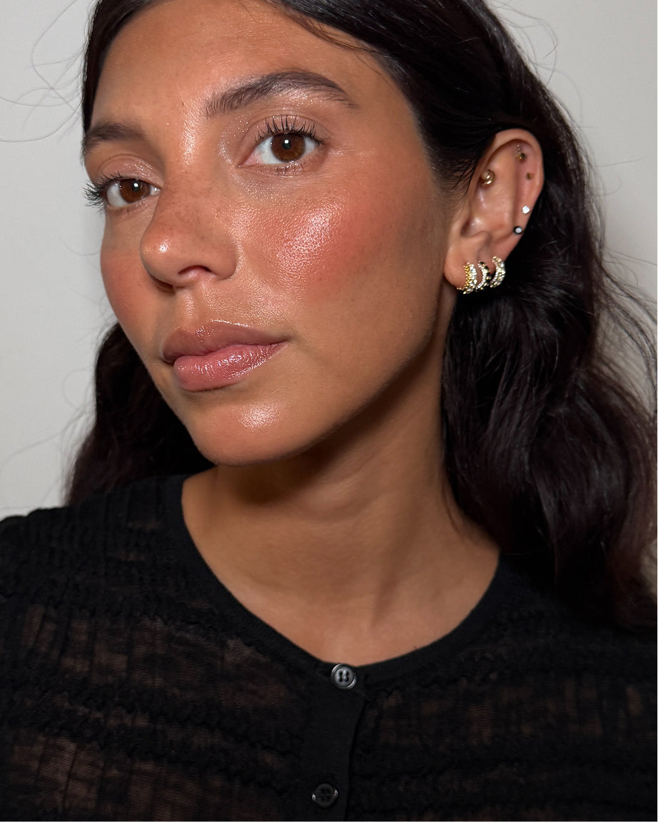 A close-up portrait of a woman wearing the Studs Halloween collection, set against a plain light gray background.