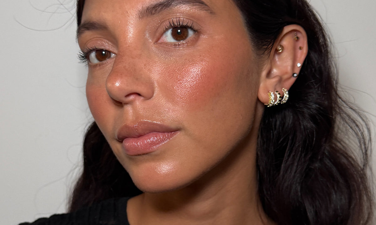 A close-up portrait of a woman wearing the Studs Halloween collection, set against a plain light gray background.