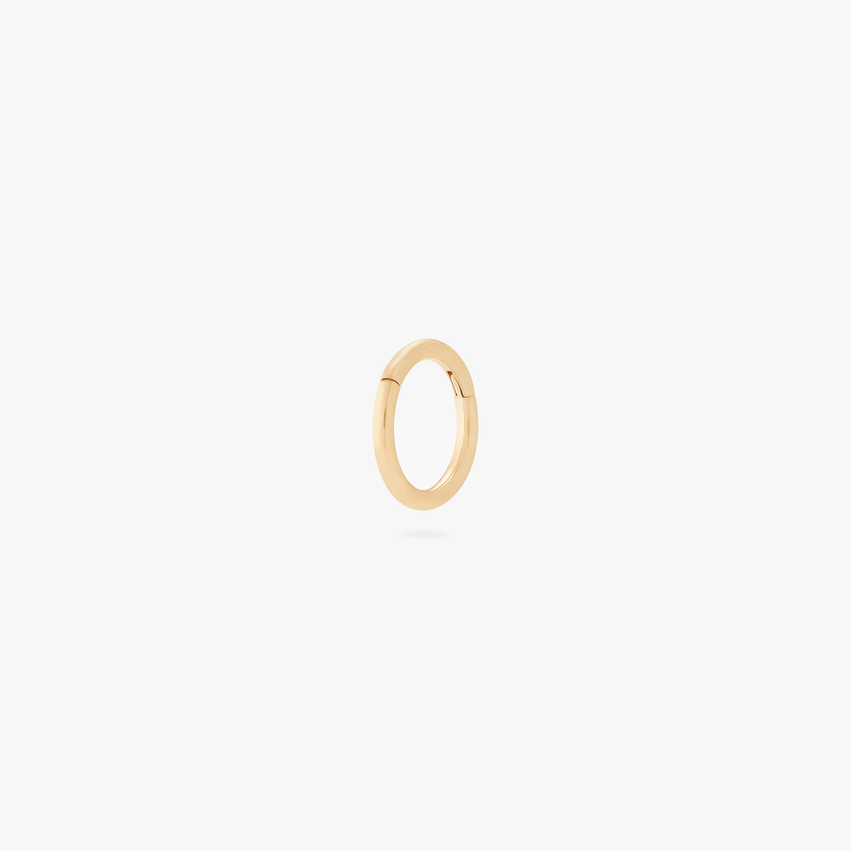 This is an image of a gold-toned titanium clicker with a 5mm diameter and a hinge closure. 