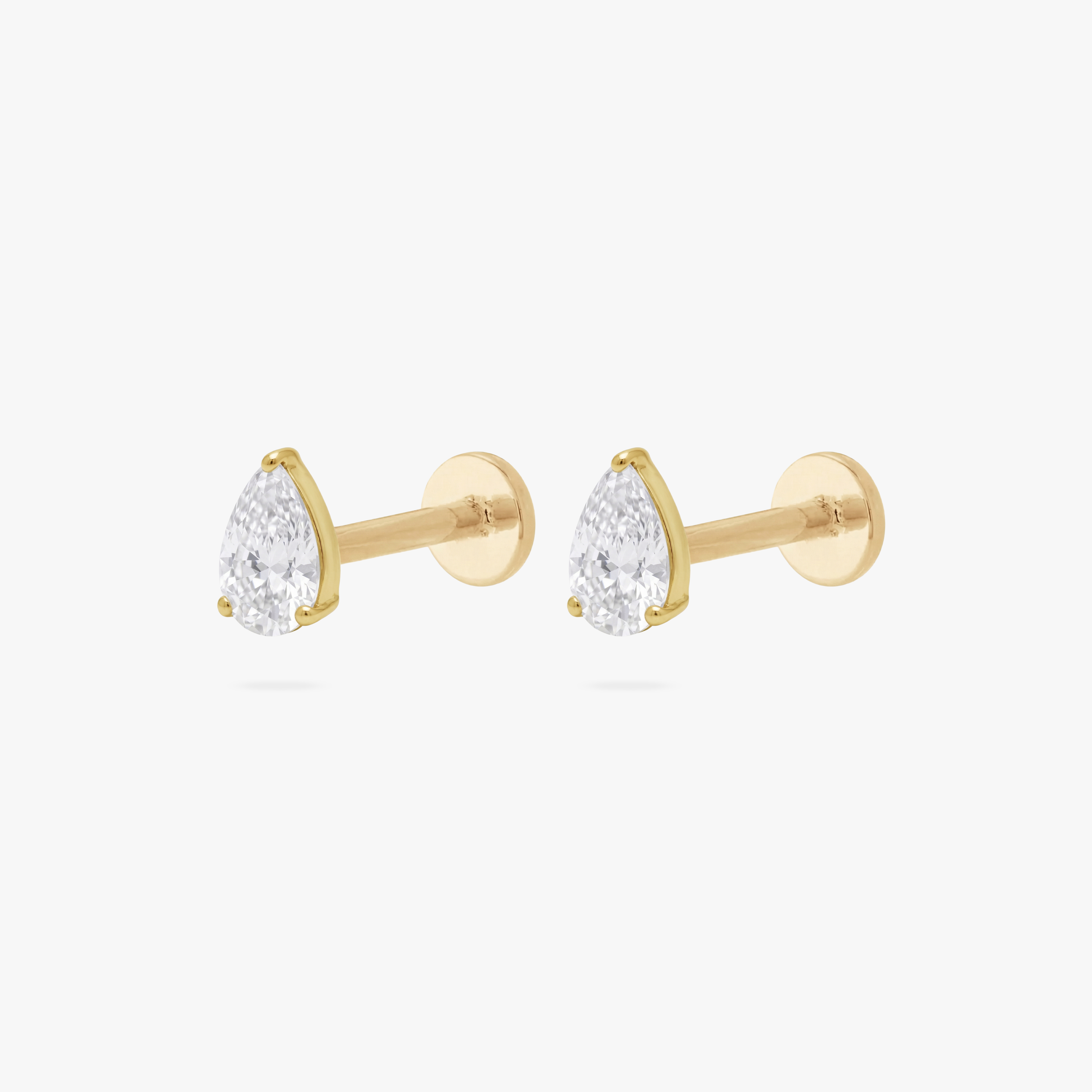 This is an image of a pair of gold toned flatback studs with 5mm clear, pear cut CZs . - Pair view