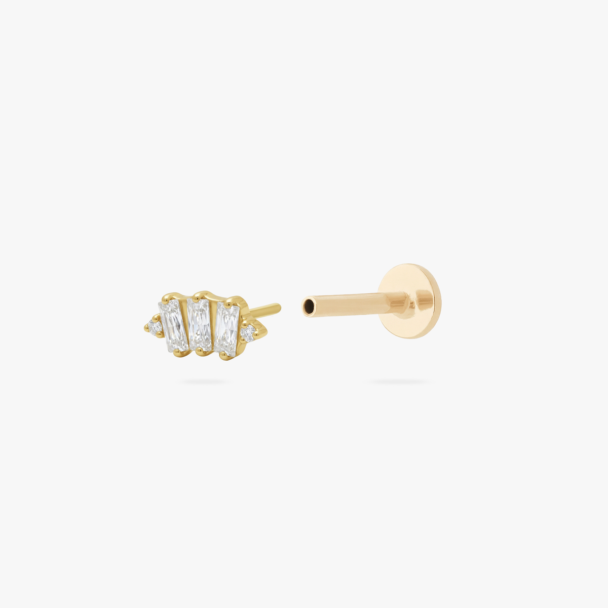 This is an image of a gold toned flatback stud which displays three clear, baguette cut CZ stones in a crown shape with two round, clear CZ stones on both ends of the crown. 