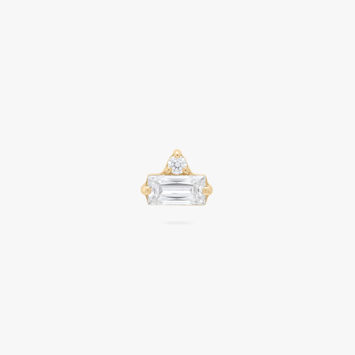 Gold flatback earrings with a small round and baguette stone on a white background