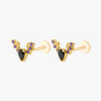This image shows the side view of a pair of the golden titanium bat flatbacks with a center black cz stone and purple mini cz stones on the wings 