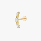 This is an image of a gold toned flatback stud that is in the shape of a curved bar and consists of three baguette cut, clear CZ stones.