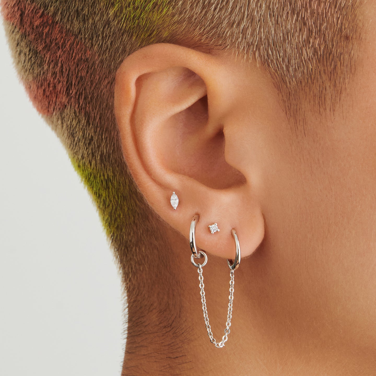 A silver small slim huggie with a connector chain with a 4mm open jump ring on ear. [hover] color:null|silver