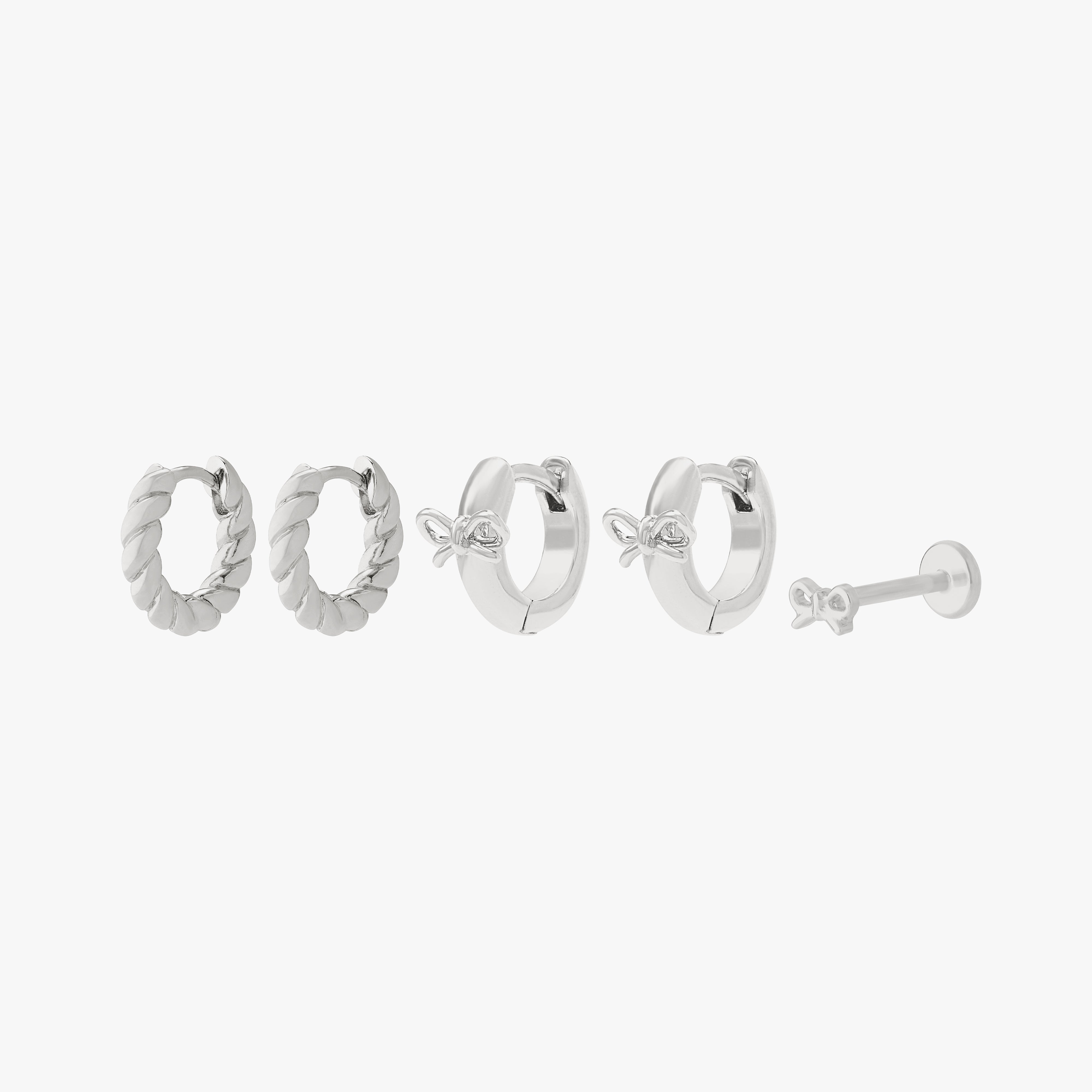 earscape set including a pair of chunky french twist huggies, a pair of micro bow huggies, and a bow flatback stud in silver color:null|silver