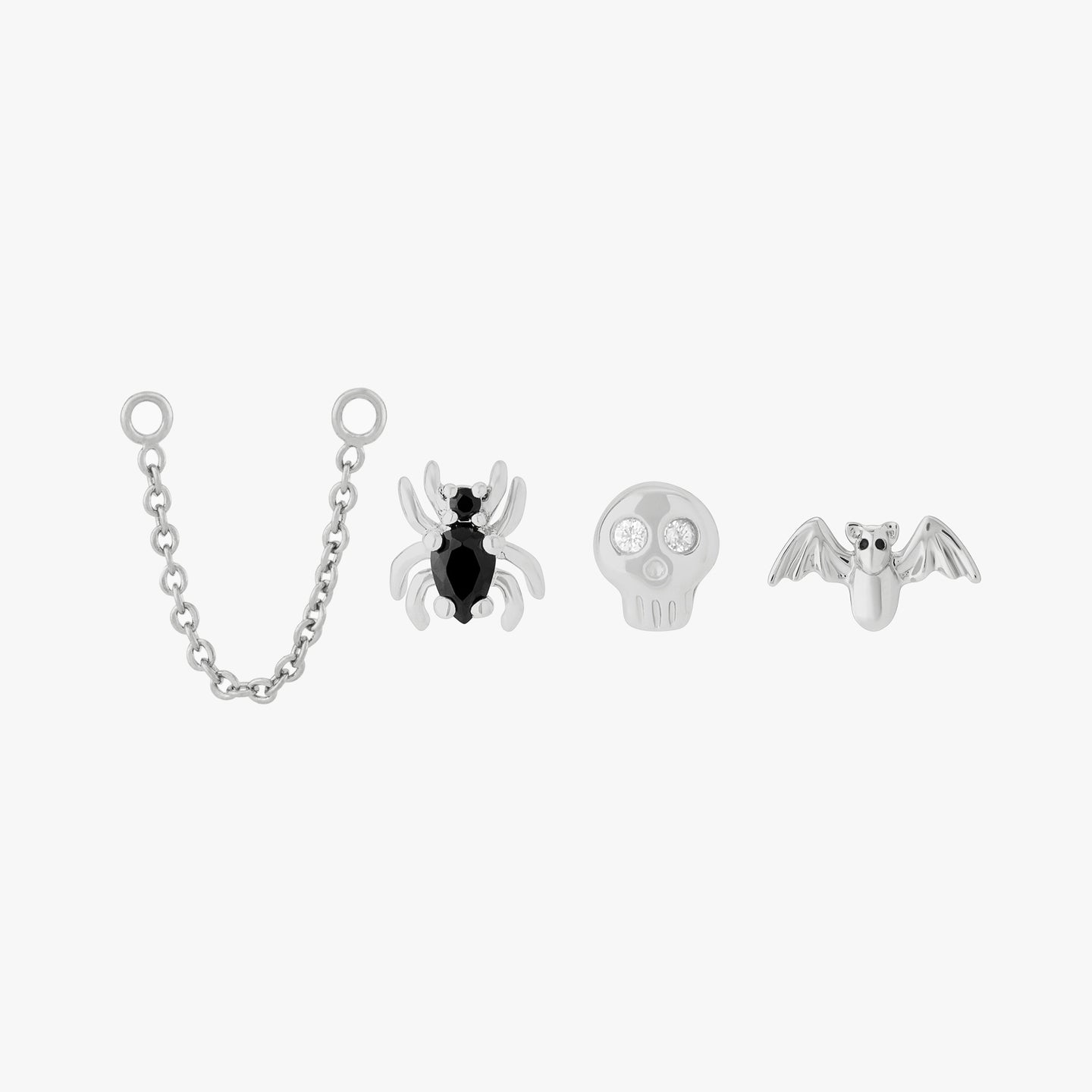 spooky set featuring a connector chain, bat stud, skull stud, and spider stud in silver color:null|silver