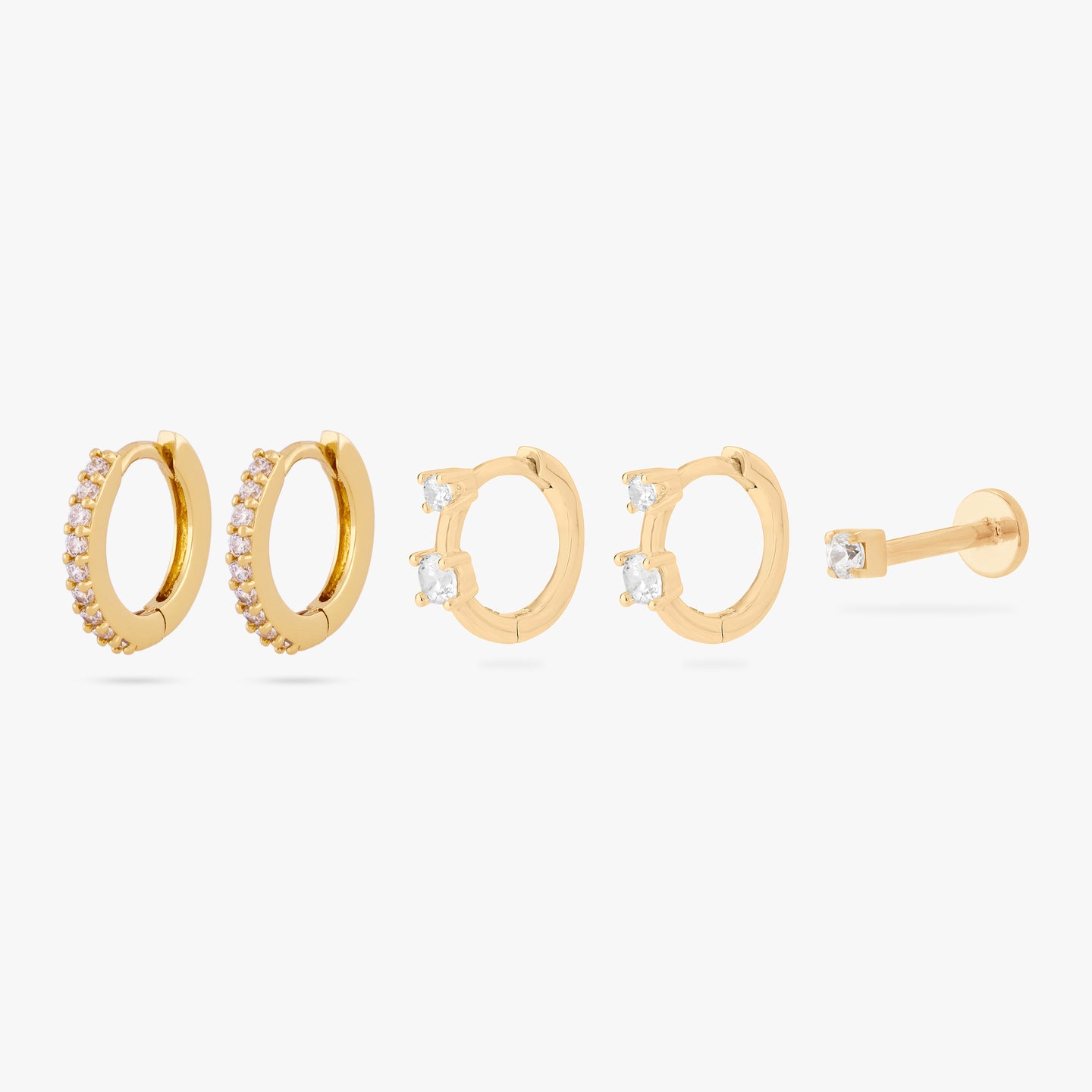 set including a pair of mini pave huggies, a pair of micro duo cz huggies, and a mini cz flatback stud in gold color:null|gold/clear