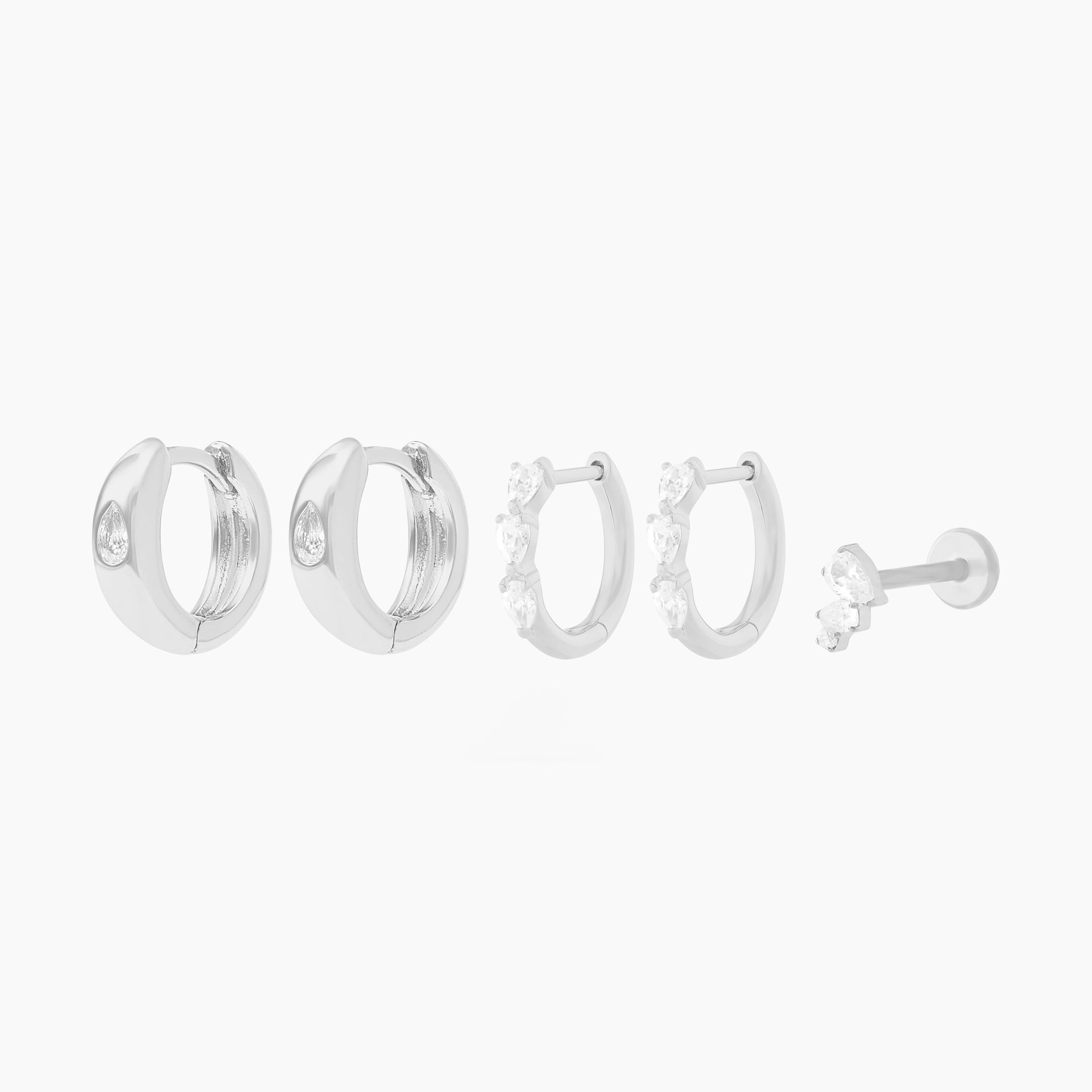 This Pear Starter Set includes 2 mini pave pear huggies, 2 chunky pear cz huggies, and one pear cluster flatback stud. These styles are all silver-toned with clear CZ stone accents. - Main view