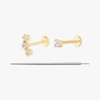 This image displays a set of two 14K gold flatback studs and a flatback insertion tool. The two earrings included in this set are the 14K Mini CZ Flatback Stud in gold/cleat, as well as the 14K Cluster Flatback Stud in gold/clear.