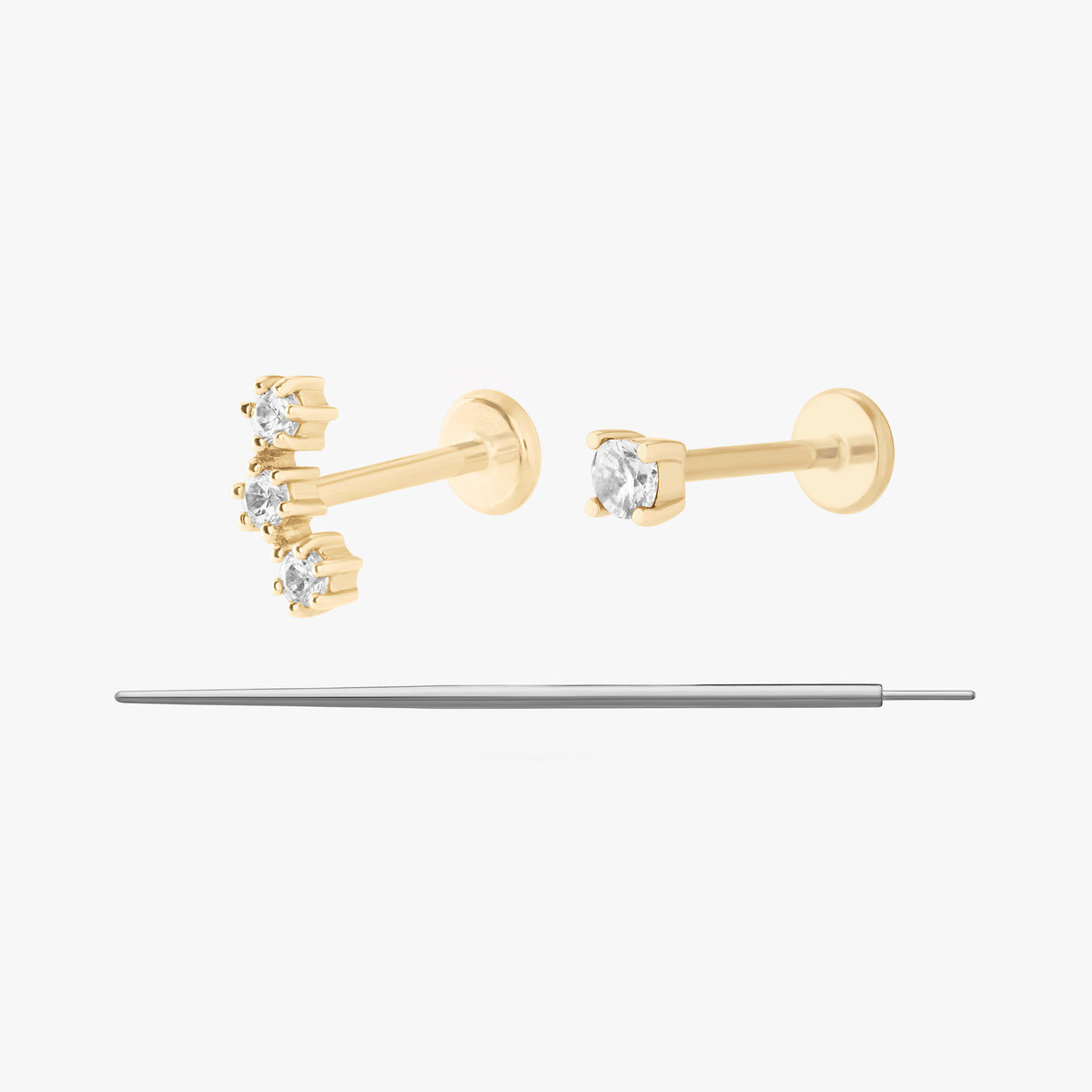 This image displays a set of two 14K gold flatback studs and a flatback insertion tool. The two earrings included in this set are the 14K Mini CZ Flatback Stud in gold/cleat, as well as the 14K Cluster Flatback Stud in gold/clear.
