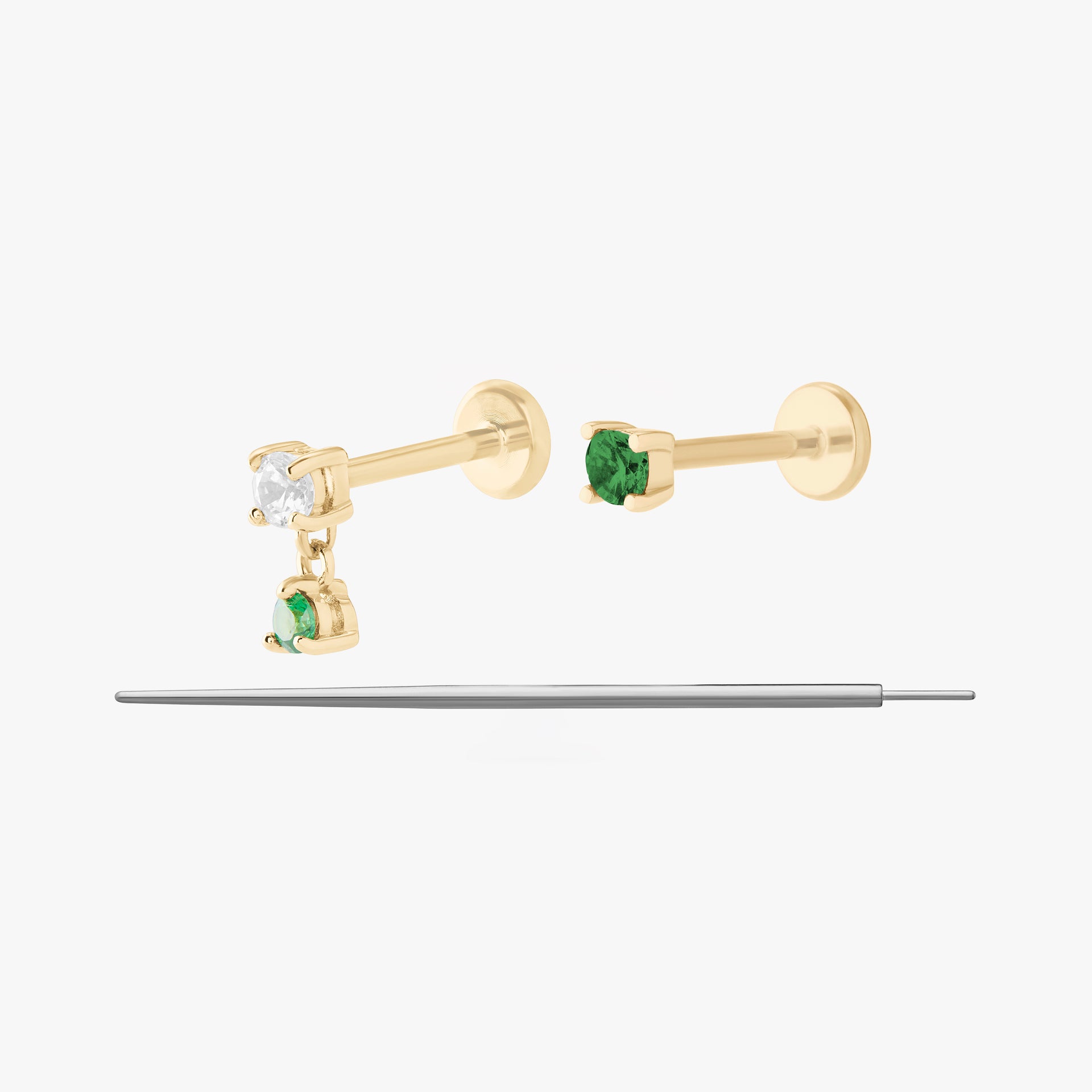 This image displays a set of two 14K gold flatback studs and a flatback insertion tool. The two earrings included in this set are the 14K Mini CZ Flatback Stud in gold/green, as well as the 14K CZ Dangle Flatback Stud in gold/green.