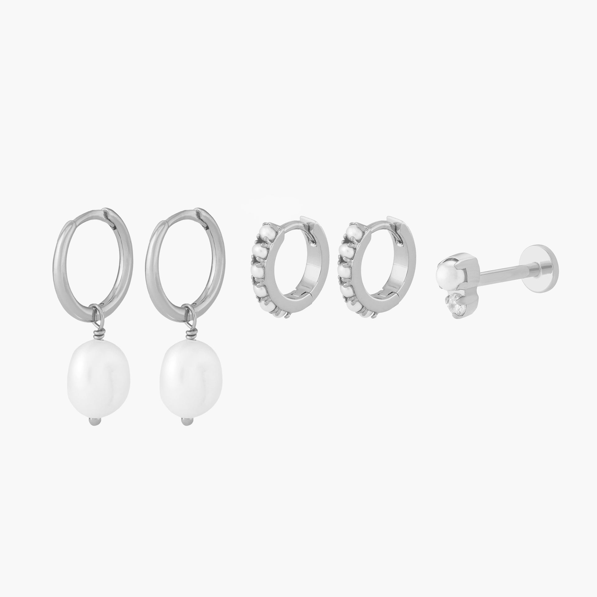 This Pearl Starter Set includes 2 baroque pearl huggies, 2 pearl huggies, and one stacked cz pearl flatback stud. These styles are all silver toned with pearl accents. - Main view