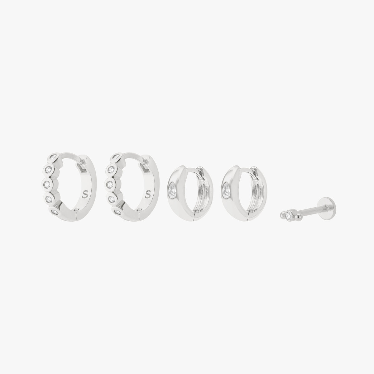This is an image displaying the silver/clear version of the Bezel Starter Set. The set includes a pair of CZ Bezel Huggies, a pair of Chunky Pear CZ Huggies, and a single Micro Bezel Cluster Flatback Stud. 