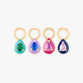 This image shows the pear enamel charm set which includes all four colored enamel charms. The four charms have a cz stones in the middle and come in the colors green, red, pink and purple 