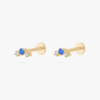 this image shows a pair of gold plated micro cluster flatbacks with two clear and one blue cz stones