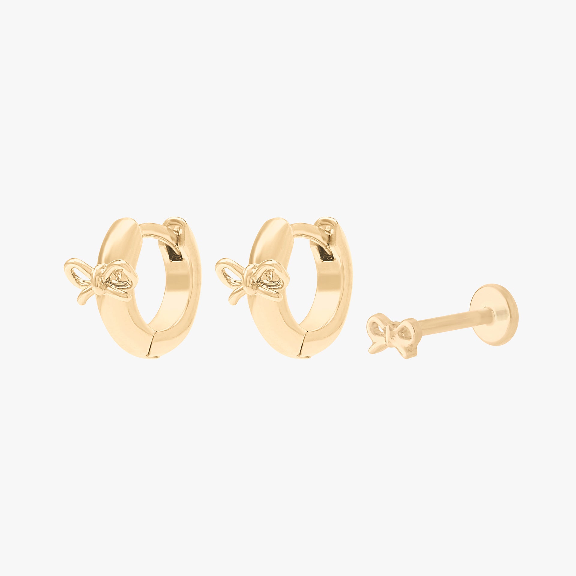 Gold earscape featuring a pair of bow huggies and a bow flatback stud - Main view