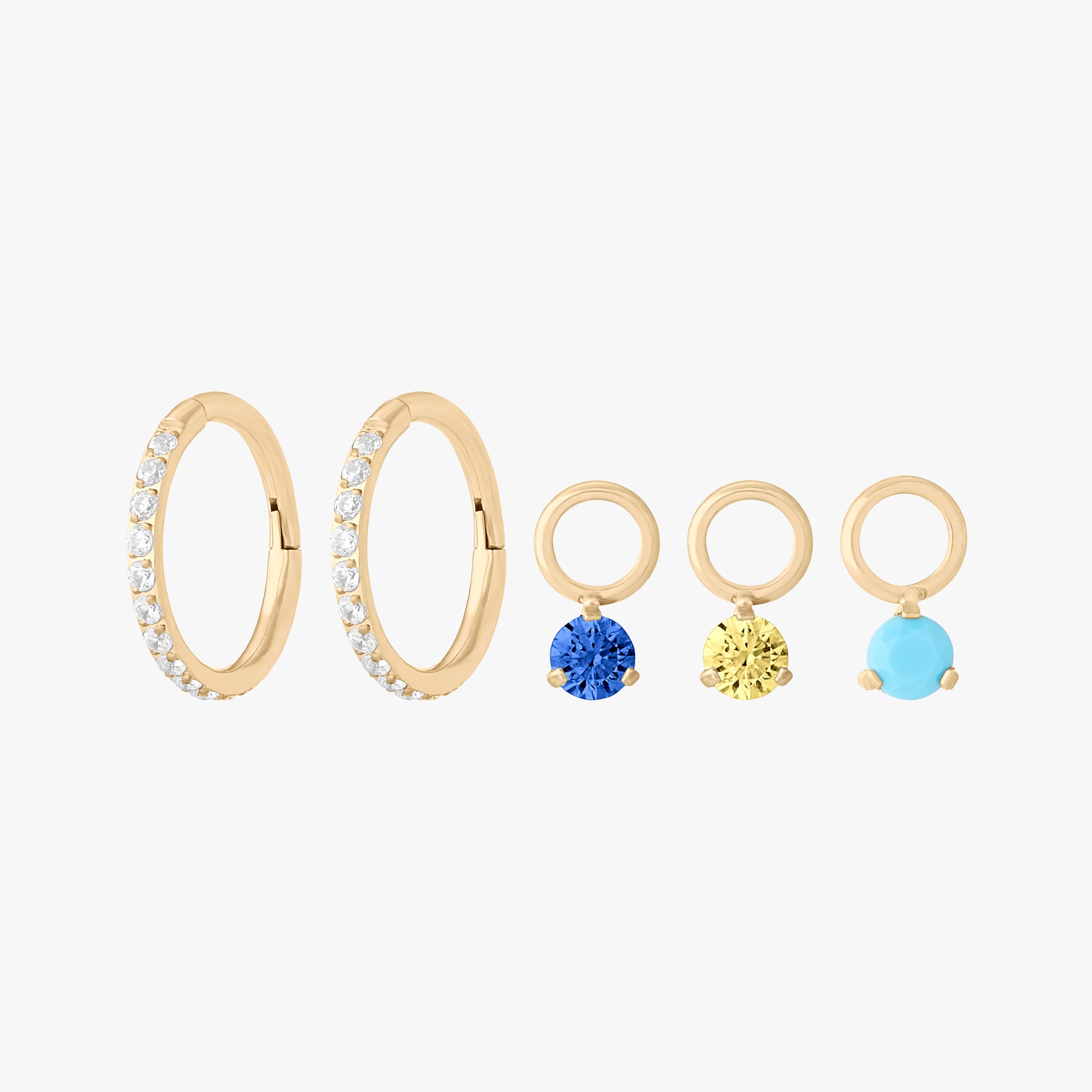 This image shows a clicker charm starter set which includes two 8mm pave clickers and three micro CZ clicker charms in sapphire, topaz, and turquoise.