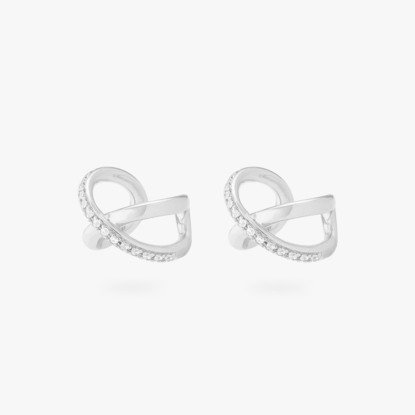 This is an image of a pair of silver twist cuffs that have one side of the twist diagonally lined with silver/clear CZs. [pair] color:null|silver/clear